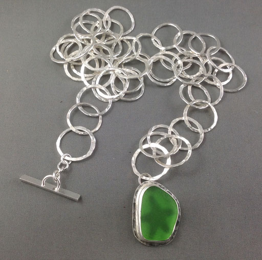 A long lariat style hammered chain with a bright green sea glass pendant and a starfish "peekaboo". 