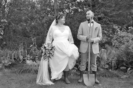 Brautpaar mit Gummistiefeln und Gartenwerkzeug im eigenen Garten in Beckum