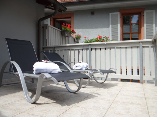 Terrasse mit Sonnenliegen des Wohlfühlbereich.  