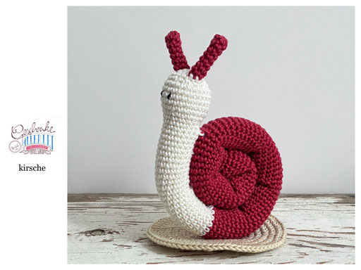 gehäkelte Schnecke mit naturweißem Körper und einem Schneckenhaus in der Farbe kirsche - Häkelschnecke - Häkeltier - Häkelspielzeug