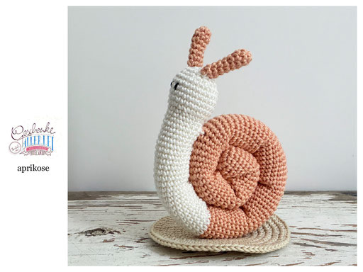 gehäkelte Schnecke mit naturweißem Körper und einem Schneckenhaus in der Farbe aprikose - Häkelschnecke - Häkeltier - Häkelspielzeug