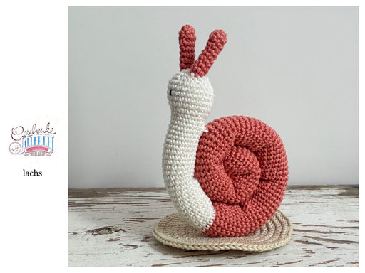 gehäkelte Schnecke mit naturweißem Körper und einem Schneckenhaus in der Farbe lachs - Häkelschnecke - Häkeltier - Häkelspielzeug