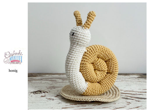 gehäkelte Schnecke mit naturweißem Körper und einem Schneckenhaus in der Farbe honig - Häkelschnecke - Häkeltier - Häkelspielzeug