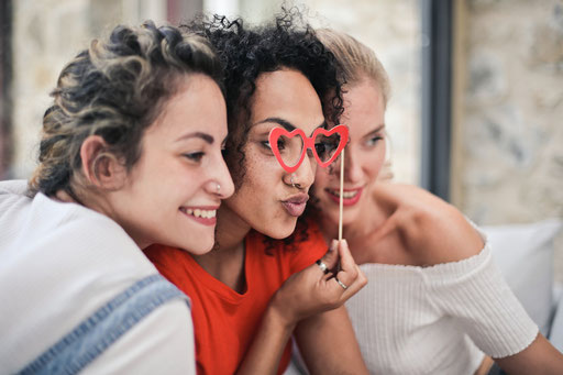 3 Freundinnen mit Props auf einer Firmenfeier vor einer gemieteten Fotobox