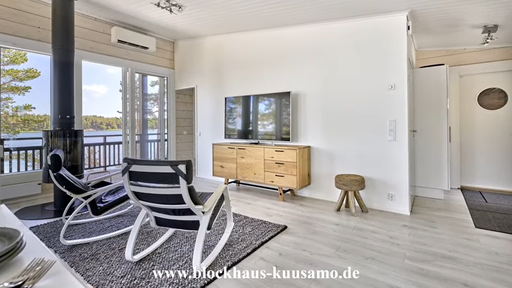 Wohnzimmer mit Kamin im Holzhaus in echter Blockbauweise
