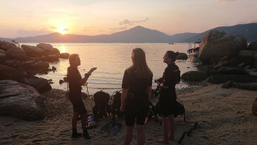 Divemaster Rainbow Divers getting a briefing at sunset before night dive in Whale Islanf, Vietnam