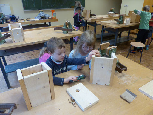 Ferienkinder beim Nistkastenbau. Auch die Kleinen sind schon fingerfertig mit dem Akkuschrauber!