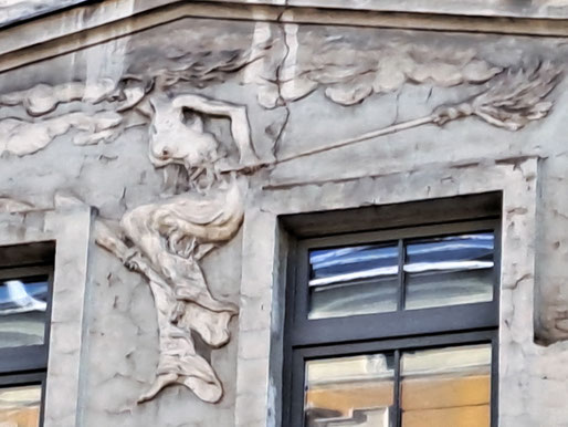 Sculpture of a witch with a broomstick on a building facade in central Riga