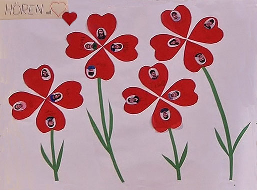 Altarbild zeigt eine Blumencollage mit Fotos und Namen der 16 Erstkommunion Kinder zum Thema "Hören mit Herz".