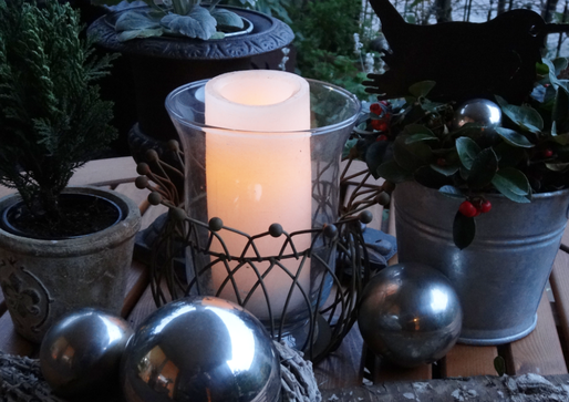 Bild: Winterliche Dekoration im Garten, Kerzenlicht, Tannenbäumchen und Weihnachtskugeln