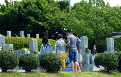 お花を持ってお墓参りに訪れたファミリー