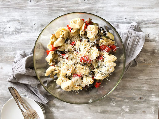 Tortellini Salat mit Anti Pasti, z.B. Paprikaschoten, Aubergine, Zucchini und Champignons, gewürzt, gedünstet und mit gekochten Tortellini vermischt, vegan möglich