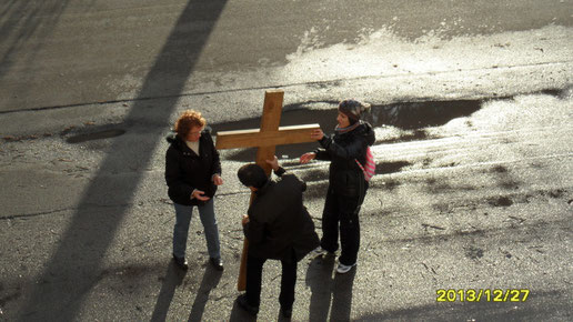 Siamo arrivati al rione Paradiso. Un momento di sosta prima di riprendere il cammino. Nino aiuta a sistemare per terra la croce che fin qui è stata trasportata a spalla.