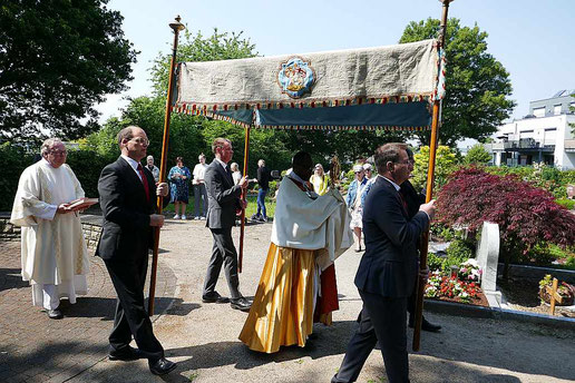 Foto, das zeigt Pastor Dominik Ekweariri, wie er unter dem Himme die Monstranz trägt.