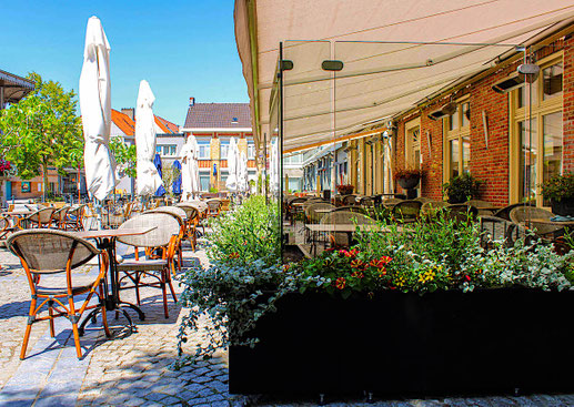 Kombination aus Windschutz-System Casablanca und großen Gastronomie-Schirmen für einen rundum geschützten und attraktiven Außenbereich