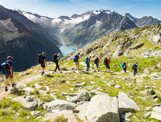 Berliner Höhenweg: Wandergruppe mit Blick auf den türkisblauen Schlegeisspeicher in den Zillertaler Alpen