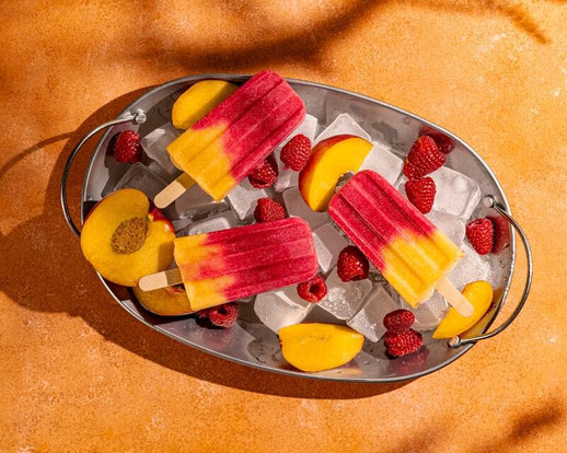 Foto von einer Platte mit eisgekühlten Aprikosen, Himbeeren und leckerem Wassereis, als perfekter Snack bei der aktuellen Hitzwelle in Deutschland