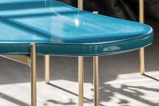 Die aus französischen Lavastein gefertigten Tischplatten erinnern mit ihren geschwungenen Formen an die Natur und werden mit filigranen Tischgestellen aus Messing ergänzt.