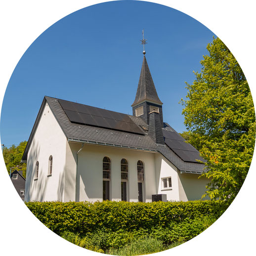 Außenansicht des Ferienhauses "Kleine Kapelle" in Netphen mit Grün drumherum und blauem Himmel