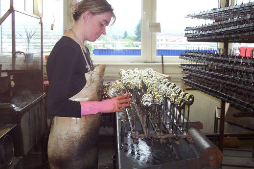 Hier werden Glasrohlinge mit Farbe, meistens in Gold grundiert,  damit die Bemalung hält.