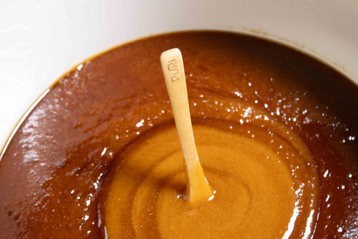 Photo d'une cuillère posée dans un seau de 10 kg de Miel de Manuka NPA 24+ de Nouvelle-Zélande