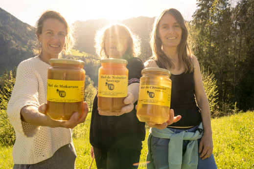 Photo de l'équipe du Comptoir du Miel dans la nature avec des pots de Miel dans leur main