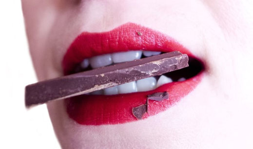 Atelier dégustation en pleine conscience au Pertuis – Gros plan d'une personne savourant un carré de chocolat noir, illustrant l'éveil des papilles et la pause gourmande lors d'une séance avec Gaëlle Pagès.