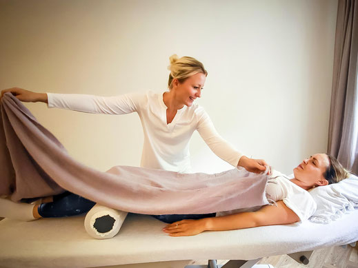 Anne-Kathrin Harders deckt eine Patientin sanft auf der Liege zu