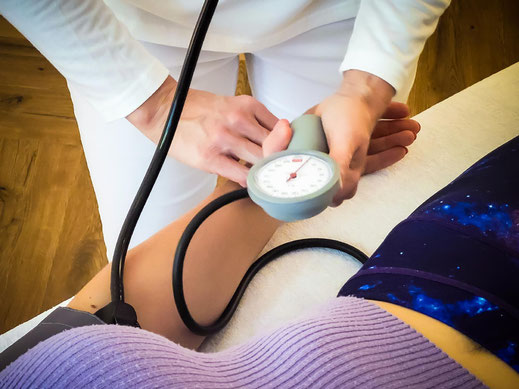 Im Rahmen der Herz-Kreislauf-Untersuchung wird bei einer Patientin der Blutdruck gemessen 