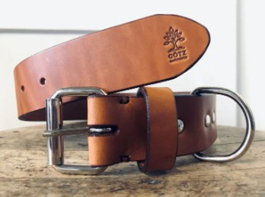 Brauner handgefertigter Ledergürtel mit Götz-Logo-Prägung auf Holz
