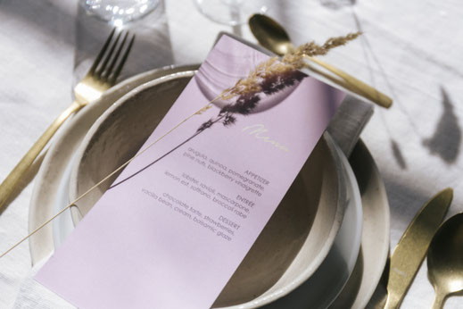 Festively set table in a minimalist setting with handmade dinnerware and close-up of a menu