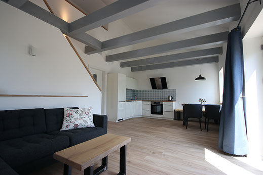 Wohnzimmer mit offener Balkenlage in der Ferienwohnung Schäfer's Loge
