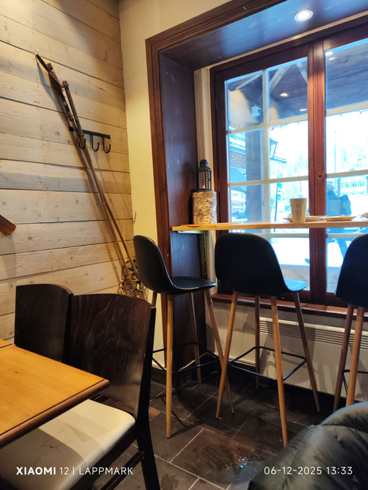 Interieur van de Flällkonditori Vemdalenskalet met Skiattributen aan de met hout beklede muren. 