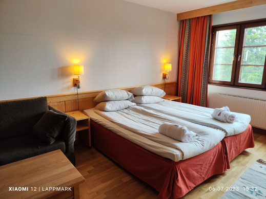 De kamer die ik eerder bezocht met mijn zus is werkelijk een warme ruimte met een gezellig bankje en tafeltje naast het bed. 