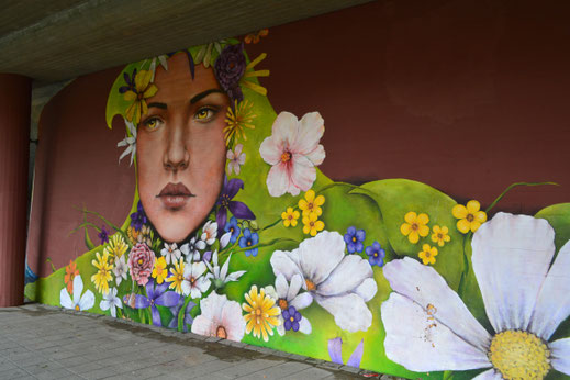 Een mooie vrouw geflankeerd met bloemen. 