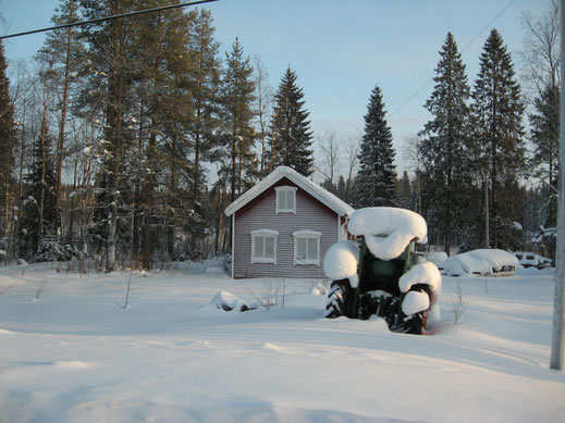 Gaststuga met ingesneeuwde tractor.