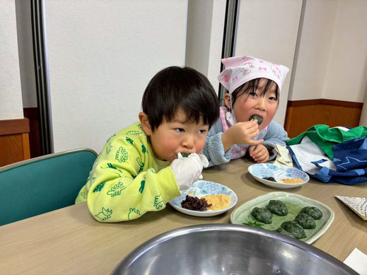 自分で作った特製のよもぎ餅を、2人の日本人の子供が嬉しそうに美味しそうに頬張っている笑顔のカット。