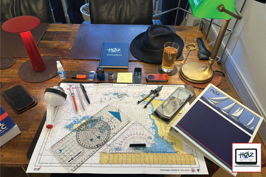 Hochseeschein Navigation: Original Seekarte, HOZ Jachtlogbuch und professionelles Kursmaterial auf Schreibtisch zur Prüfungsvorbereitung