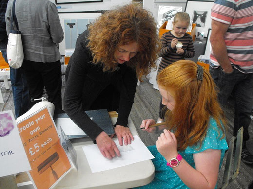 Lucy demonstrating dry point etching at Art In The Pen Skipton