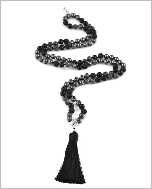 Das Foto zeigt eine Mala Kette, Gebetskette, mit Quaste und verschiedenen Edelsteinen. 
