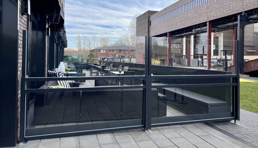 Windschutz Modell Athen auf einer modernen Restaurant-Terrasse – halbseitig ausgefahrenes „Up & Down“-System zur flexiblen Anpassung an Wind und Wetter