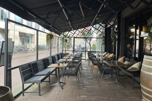 Scherenarm Markise und Windschutzwände aus Sicherheitsglas in Sonderhöhe an einer Terrasse bei einem Hotel