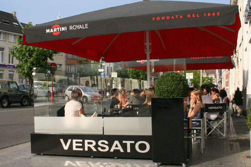 Eleganter Windschutz mit satiniertem Unterteil als Sichtschutz in einem Biergarten direkt an der Strasse 