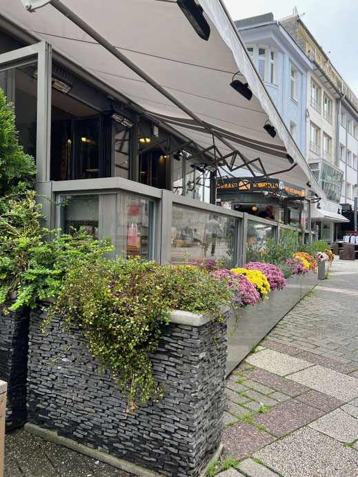 Terrasse am Cafe mit einer höhenverstellbaren Windschutzanlage