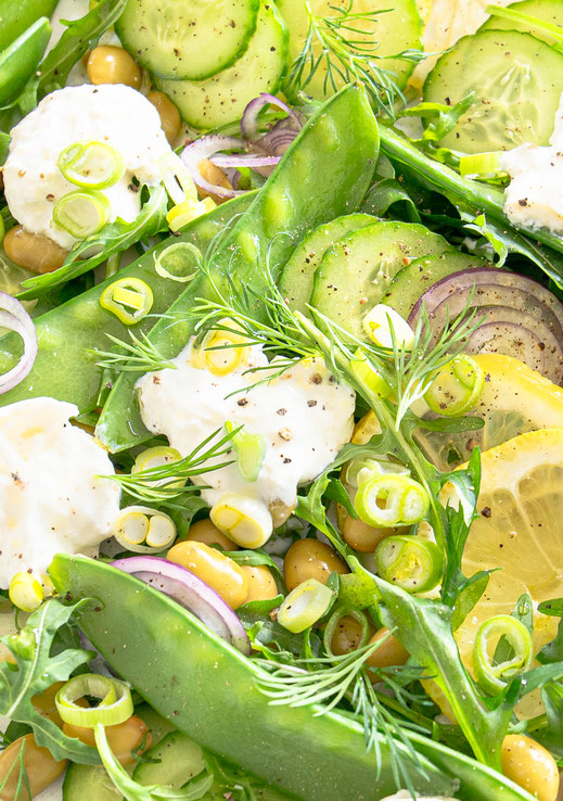 Frühlingssalat mit Rucola, Zuckererbsen, Edamame und Burrata auf einer Servierplatte