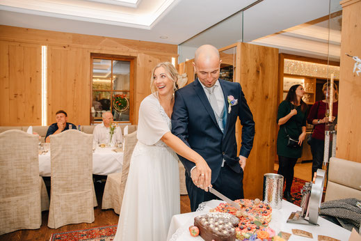 Hochzeit Hall in Tirol Gartenhotel Location Hochzeitstorte Anschnitt Kuchen Brautpaar Liebe Spaß