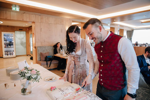 Hochzeit Sistrans Standesamt Feier Gasthof Walzl Lans Tortenanschnitt Brautpaar Braut und Bräutigam schneiden Torte an Braut kneift Augen zu