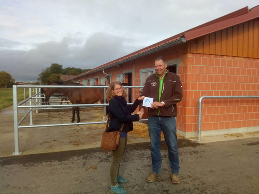 Tina Hoffmeister überreicht Burkhard Steinbach die Plakette "Schwalbenfreundliches Haus"