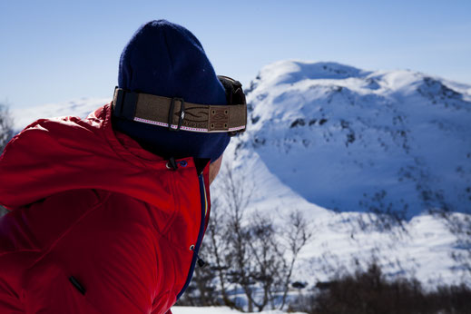 Man in red ski jacket looking at a mounatin