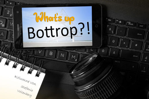Handy, Kamera und Notitzblock liegen auf Laptoptastatur, Handy zeigt Titelbild von Kolumne: Schriftzug Whats up Bottrop?!